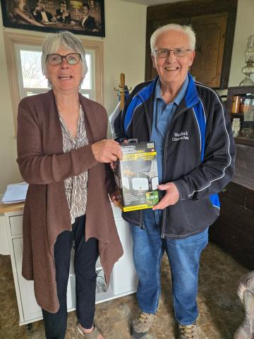 two volunteers holding up a box with a light inside